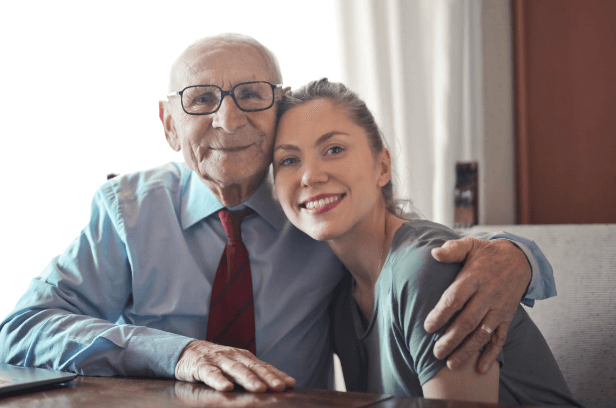 older man with glasses and younger woman smiling
